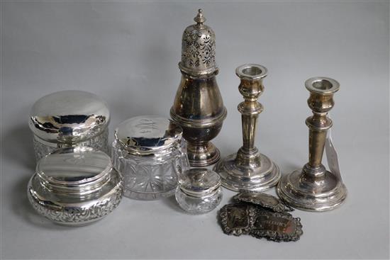 A pair of silver dwarf candlesticks, a silver caster, four silver wine labels and four toilet jars
